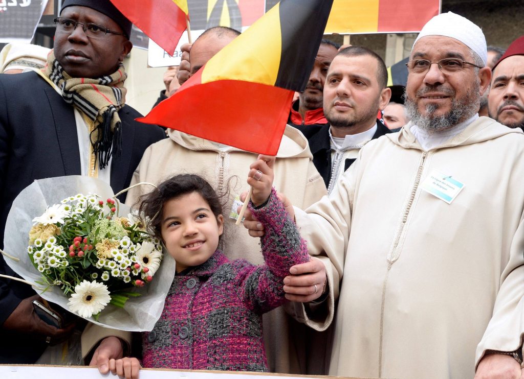 Mohamed Toujgani, à droite, lors d'un rassemblement en hommage aux victimes des attentats de Bruxelles. © AFP